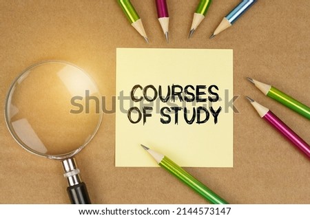 Education concept. On the table are pencils, a magnifying glass and a sticker with the inscription - Courses of study