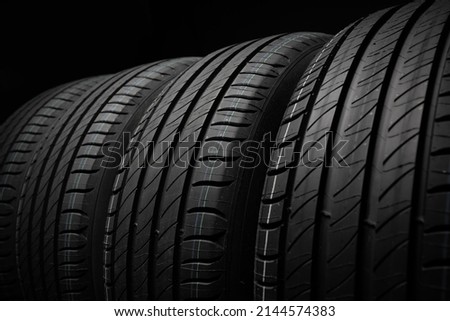 New car tires. Group of road wheels on dark background. Summer Tires with asymmetric tread design. Driving car concept. Close-up