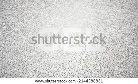 Writing gel printed on the wet glass on grey background | skin moisturizing gel commercial