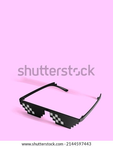 8 bit style sunglasses. Joke minimal concept. Isolated eyeglasses on pink pastel background