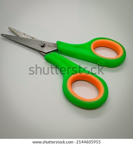 scissors green in combination with orange, on a white background