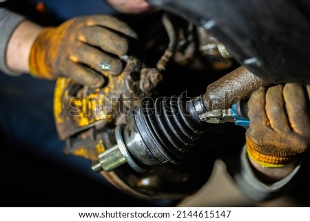 installation of the drive shaft of the joint and half shaft in the engine gearbox, a metal clamp on the rubber boot. Royalty-Free Stock Photo #2144615147