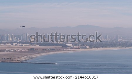 San Diego city skyline, cityscape of downtown with highrise skyscrapers, California coast, USA. View of Coronado island from above, Point Loma vista viewpoint. Helicopter flying mid air in sky.
