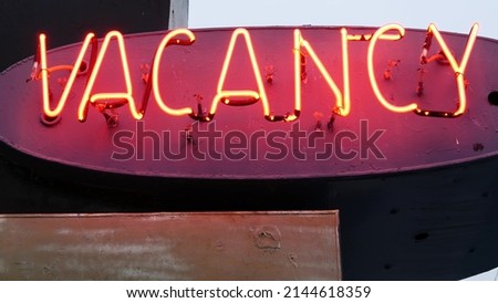 Red neon sign Vacancy glowing, motel or hotel on road in California USA. Illuminated text about lodging during road trip. Tourism or traveling in America. Royalty-Free Stock Photo #2144618359