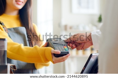 Customer using credit card for payment to owner at cafe restaurant, cashless technology and credit card payment concept Royalty-Free Stock Photo #2144620895