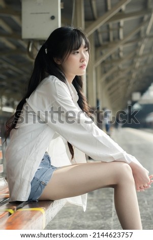 Portrait of thai japan adult beautiful girl white shirt blue jeans relax time, train station fashion