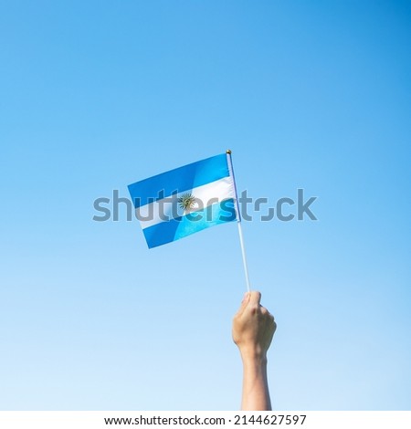 hand holding Argentina flag on nature background. 9th July of Independence day, 25th May of Revolution day and happy celebration concepts Royalty-Free Stock Photo #2144627597