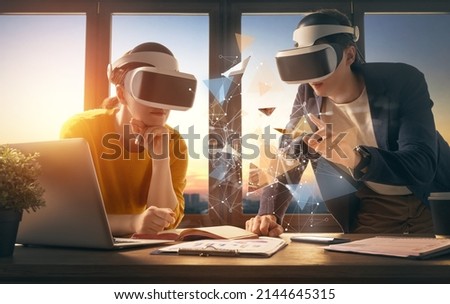Metaverse technology concept. Man and woman with VR virtual reality goggles are working in the office. Futuristic lifestyle. Royalty-Free Stock Photo #2144645315