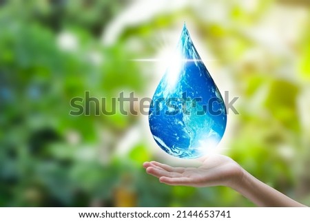 Hands holding water drop on world map. Save the world concept. Environment, save clean planet, ecology concept. Earth Day with green bokeh background and copy space for text. Image furnished by NASA.