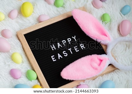 Stylish background with colorful easter eggs on white furry background with bunny ears. Flat lay, top view, mockup, overhead, template