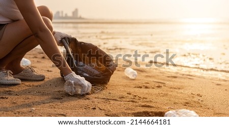 Volunteer woman picking plastic bottle into trash plastic bag black for cleaning the beach, female clean up garbage at sunset, Ecology concept and World Environment Day, Save earth concept Royalty-Free Stock Photo #2144664181
