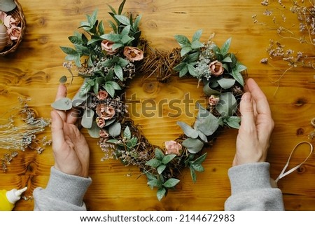 Hands makes flower wreath. DIY spring home decor idea. Step by step. Royalty-Free Stock Photo #2144672983