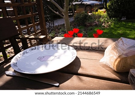 A plate and bread on a wooden table in the garden