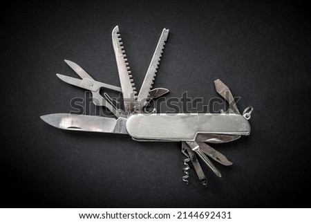 Metallic swiss knife isolated on black background