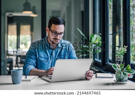 Hardworking company employee, making sure his new office laptop is working. Royalty-Free Stock Photo #2144697465