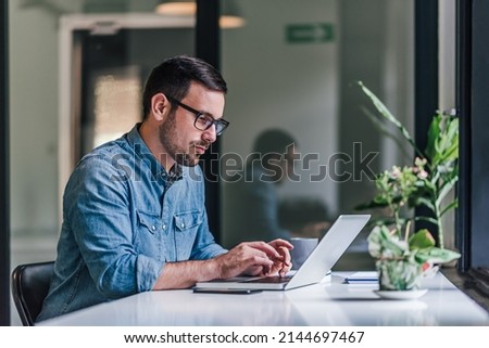 Bearded adult man, making sure there are no mistakes in the code he is writing. Royalty-Free Stock Photo #2144697467