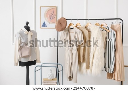 Rack with stylish clothes in modern studio of fashion stylist Royalty-Free Stock Photo #2144700787