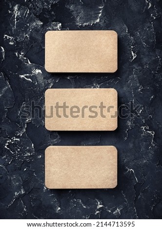 Photo of blank vintage business cards on black plaster background. Mockup for ID. Top view.