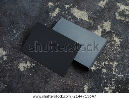 Blank grey paper business cards on concrete background. Copy space for text.