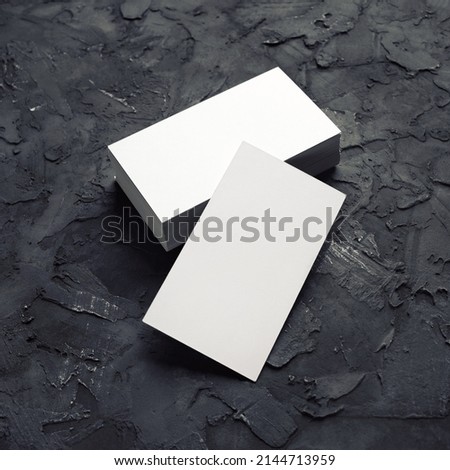 Blank white business cards on black plaster background. Mockup for branding identity. Template for graphic designers portfolios.
