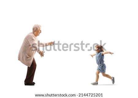 Full length profile shot of a child running towards grandmother with arms wide open isolated on white background Royalty-Free Stock Photo #2144725201