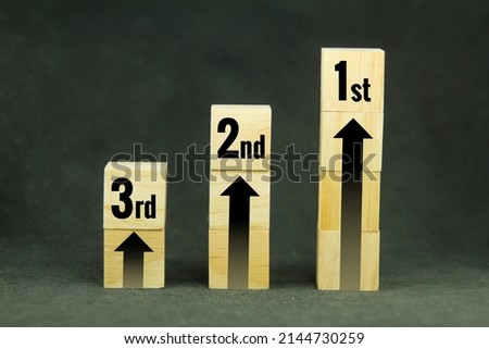 wooden cubes with arrows and first place, second place and third place Royalty-Free Stock Photo #2144730259
