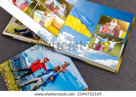 on white table open photobook from photo shoot of family with ukraine flag