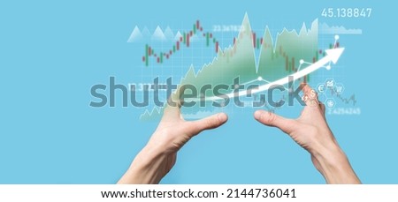 Businessman in hand hold banking business finance graph and invest in stock market investment point,economic growth and investor concept.analysis virtual stock market chart,analyze by use technology.