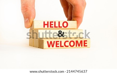Hello and welcome symbol. Concept words Hello and welcome on wooden blocks. Businessman hand. Beautiful white table white background. Business hello and welcome concept. Copy space.