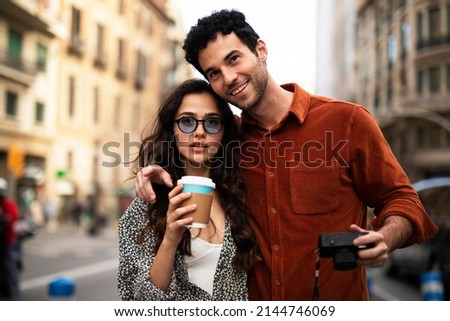 Traveling couple taking photos with camera. Loving couple walking through the city