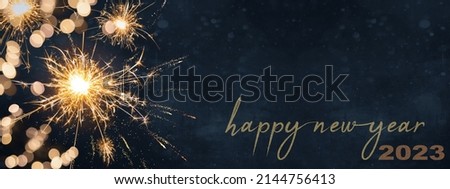 HAPPY NEW YEAR 2023, Silvester Party New year' Eve  background banner panorama long, holiday greeting card - Sparklers and bokeh lights on dark night texture
