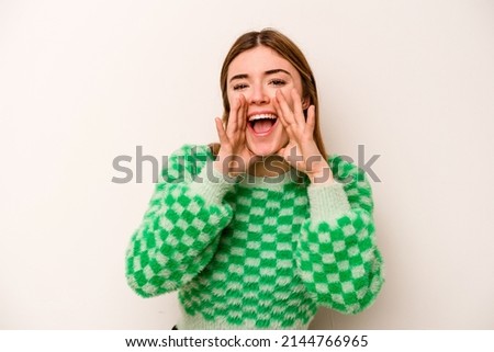 Young caucasian woman isolated on white background saying a gossip, pointing to side reporting something.