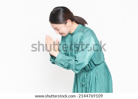A housewife who asks you to put your palms together in front of a white background Royalty-Free Stock Photo #2144769109