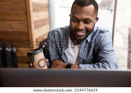 Successful male freelancer is drinking coffee at the workplace, take a break. Happy businessman sitting at the desk, thinking about ideas for project or startup. High quality photo