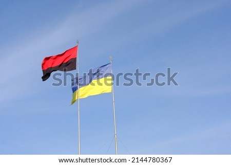 Ukrainian flag on blue sky backgroud together with flag of Ukrainian insurgent army.