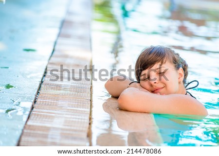 young and beautiful girl relaxes in the pool 