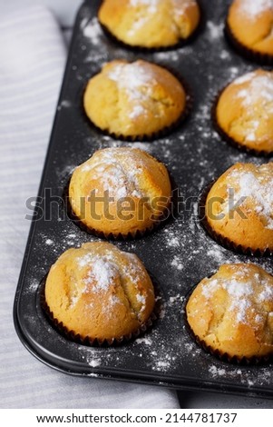 Baking tray with baked muffins on wooden white background.