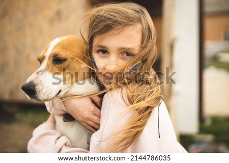 The girl is protecting her dog. Girl and her dog. A refugee from Ukraine with a dog. Animal rescue from Ukraine. Evacuation of dogs. The girl hugs and calms her dog. Royalty-Free Stock Photo #2144786035