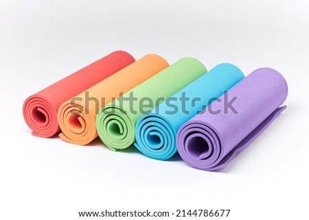 colored Yoga Mats on a white background. Close up view at exercise mats isolated on the white. many colorful yoga mats isolated on white background.