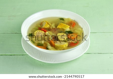 Vegetable Sop is a soup made from vegetables as the main ingredients, carrots, mustard greens, cabbage, broccoli and chicken stock for the sauce. Served in a bowl on the table. Selective focus