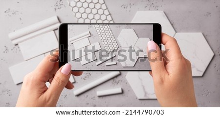 Woman taking photo of ceramic tiles with smartphone. Interior designer capturing home renovation materials for client or social media.