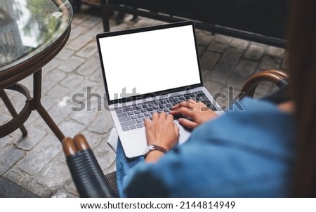 Mockup image of a woman using and working on laptop computer with blank white desktop screen in the outdoors