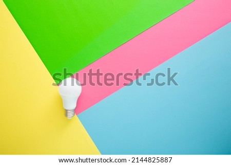 White light bulb on color background in pastel colors. Minimalist concept, bright idea concept,