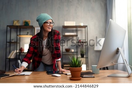 Happy female video editor works indoors in creative office studio Royalty-Free Stock Photo #2144846829