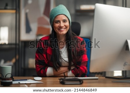 Happy female video editor works indoors in creative office studio, looking at camera. Royalty-Free Stock Photo #2144846849