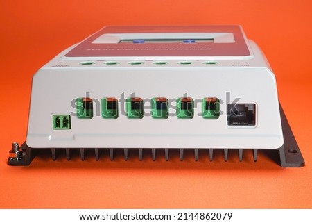 Solar charge controller for solar panel or solar electric energy, orange background isolated Royalty-Free Stock Photo #2144862079