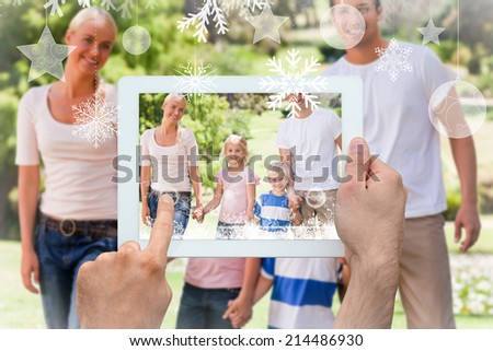 Hands holding tablet pc against adorable family during the summer