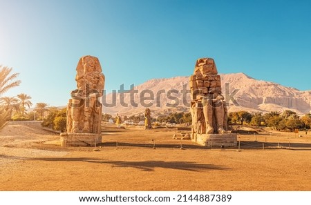 Famous two Colossi of Memnon - massive ruined statues of the Pharaoh Amenhotep III. Travel and tourist landmarks near Luxor, Egypt Royalty-Free Stock Photo #2144887389