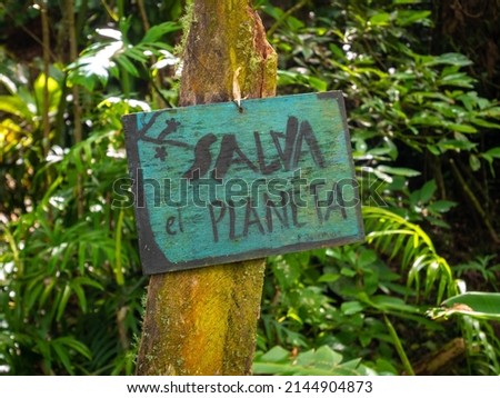 Sign on a Piece of Wood that Says "Save the Planet" in the Middle of a Garden