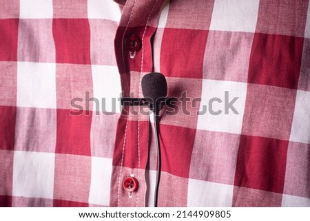 Close-up of a microphone attached to a shirt.